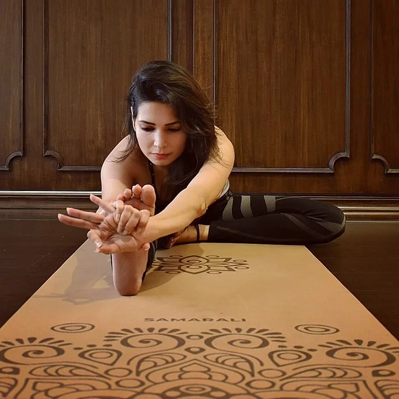 Frau in Yogapose auf nachhaltiger Kork Sun Eclipse Yogamatte, umgeben von natürlicher Umgebung.