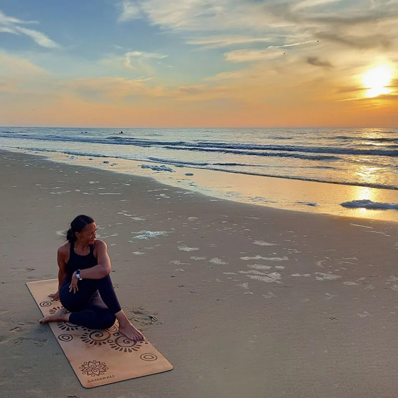Frau am Strand Sonnenuntergang in Yogapose sitzend_Moon eclipse Yogamatte
