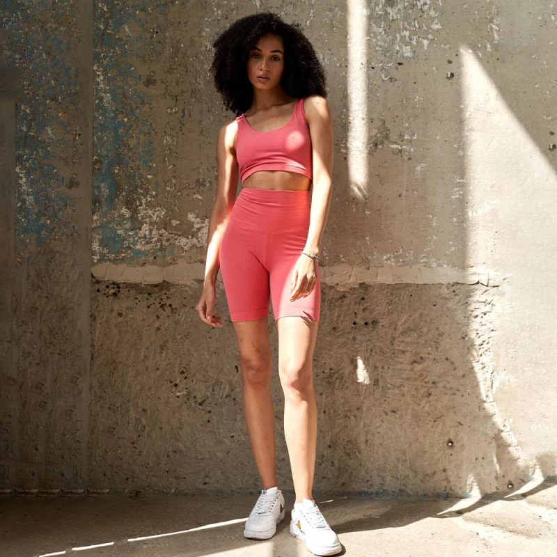 Fitness-Set mit pinken Shorts und passendem Top, ideal für das Training, sportlich und stylisch, auf hellem Hintergrund.